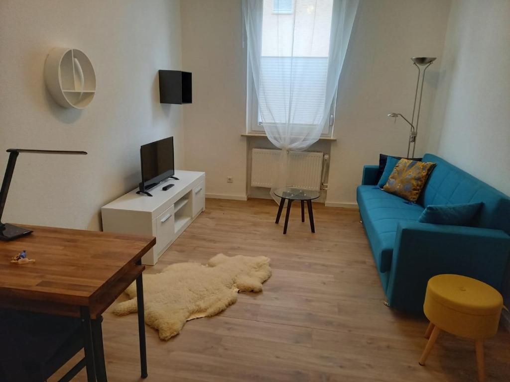 ein Wohnzimmer mit einem blauen Sofa und einem Tisch in der Unterkunft Falkennest-lu in Ludwigshafen am Rhein