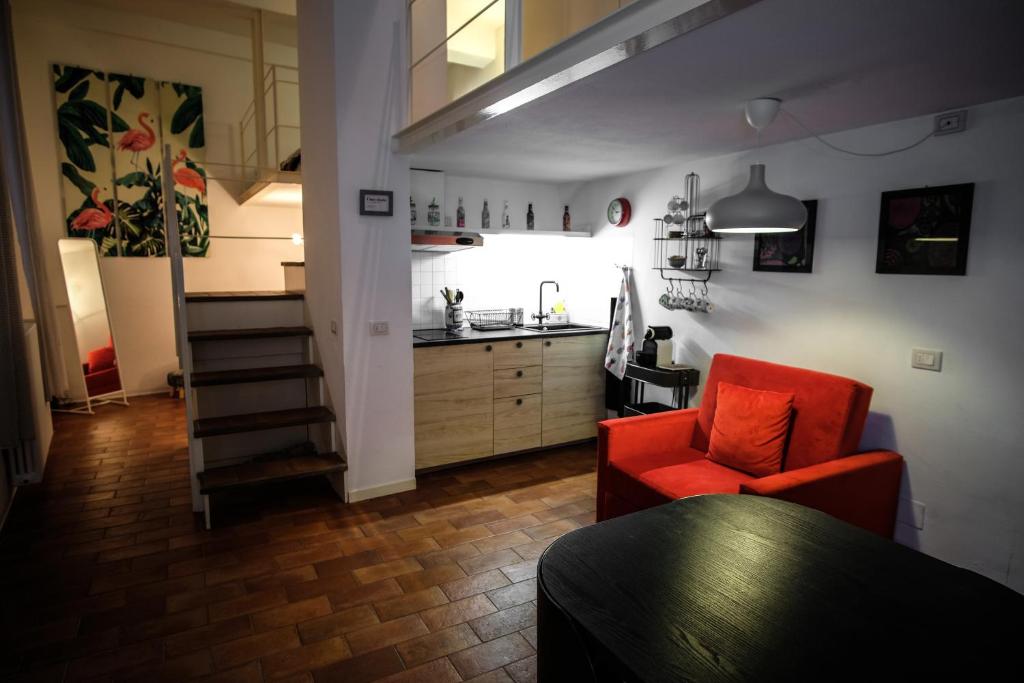 a living room with a red chair and a kitchen at Cozy House in Parma