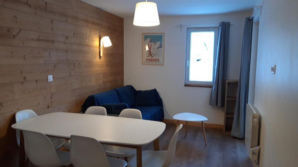 sala de estar con mesa y sofá azul en 2 Appt 4 à 6 pers Val Louron au pied des pistes, en Génos