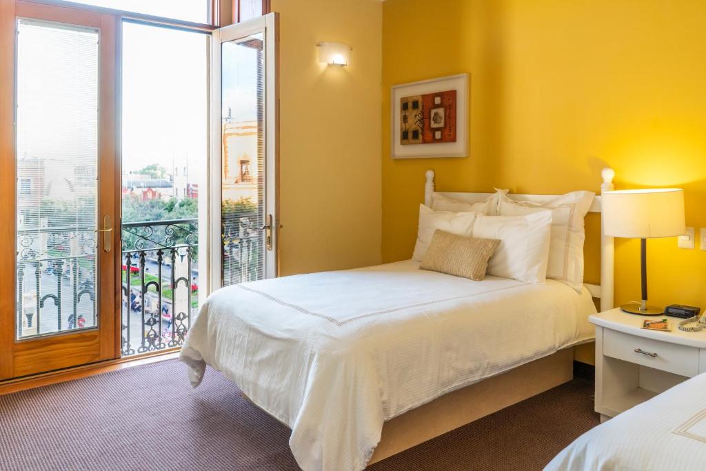 a bedroom with a large bed and a balcony at Gran Hotel de Querétaro in Querétaro