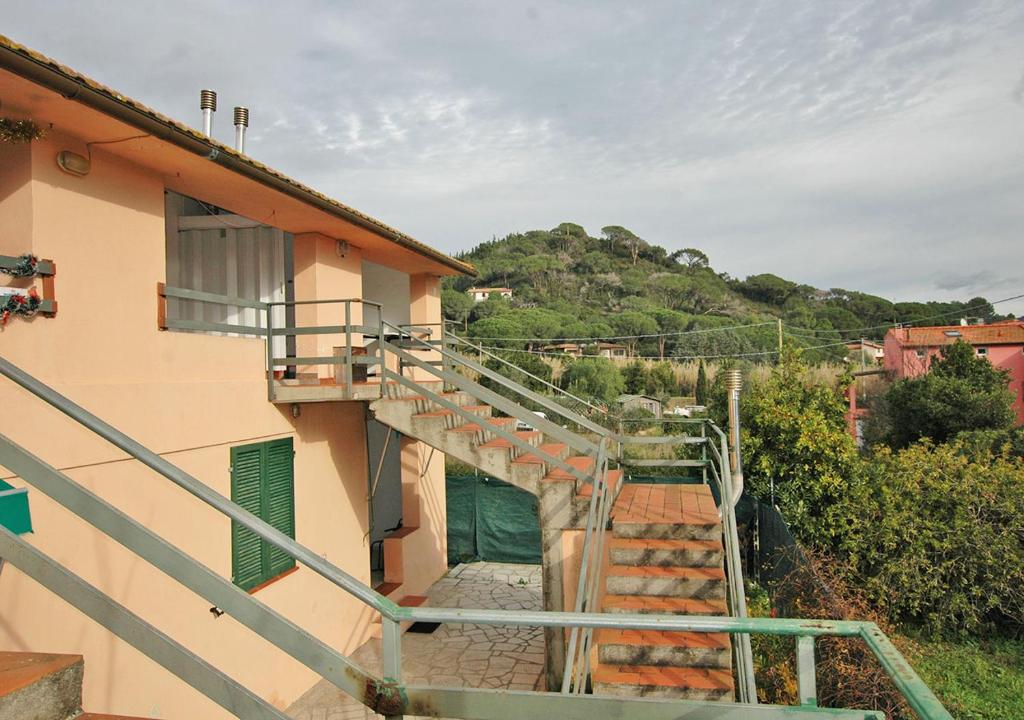 eine Treppe, die zu einem Gebäude mit einem Hügel im Hintergrund führt in der Unterkunft CASA CECILIA in Marina di Campo