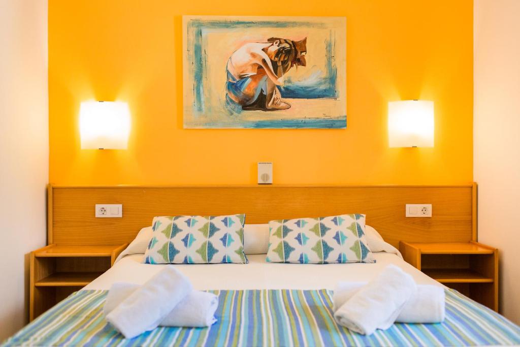 a bedroom with a bed with two pillows at Sagitario Vista Playa I Apartamentos in Cala Blanca