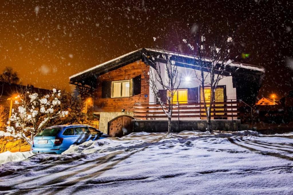 a house with a car parked in the snow at Vikend kuća Planinski raj in Pale