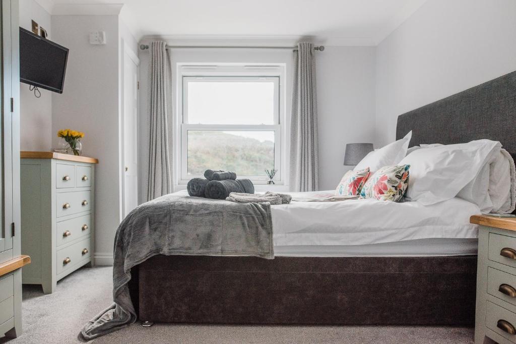 a bedroom with a large bed with a window at Number Seven in Newquay