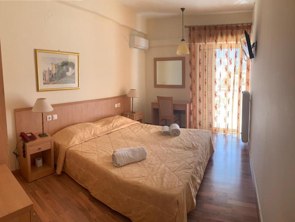 a hotel room with a bed and a television at Saronis Hotel in Ancient Epidavros