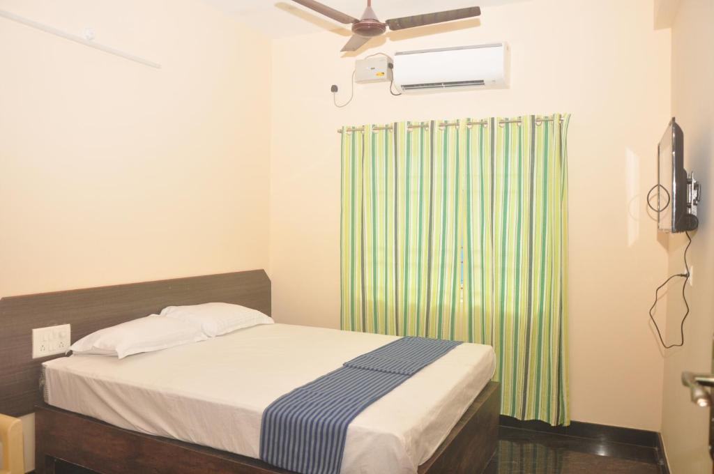 a bedroom with a bed and a green radiator at Hotel Aishwariyam in Tirukkadaiyūr