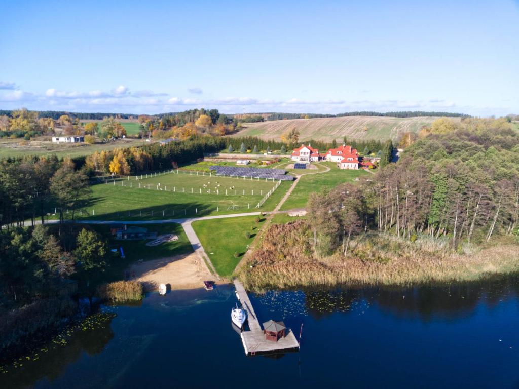 - une vue aérienne sur un lac avec un petit quai dans l'établissement Przystań nad zatoką - Osada, à Lubieszewo