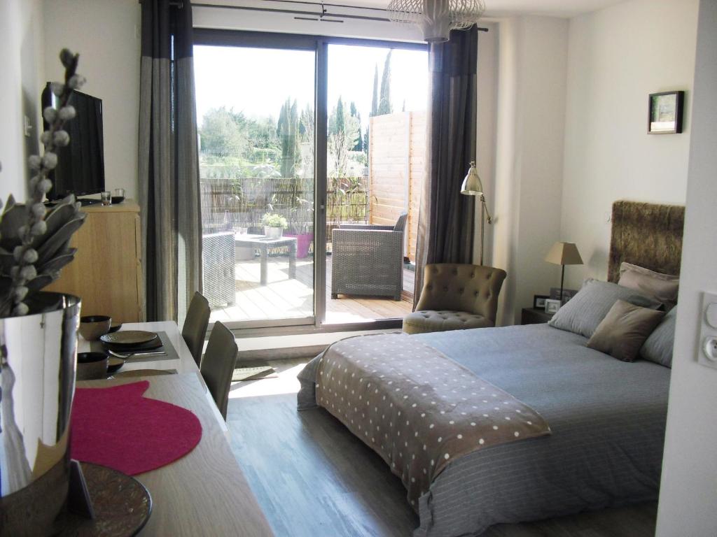 a bedroom with a bed and a view of a patio at Studio à Deux Pas d'Aix in Aix-en-Provence