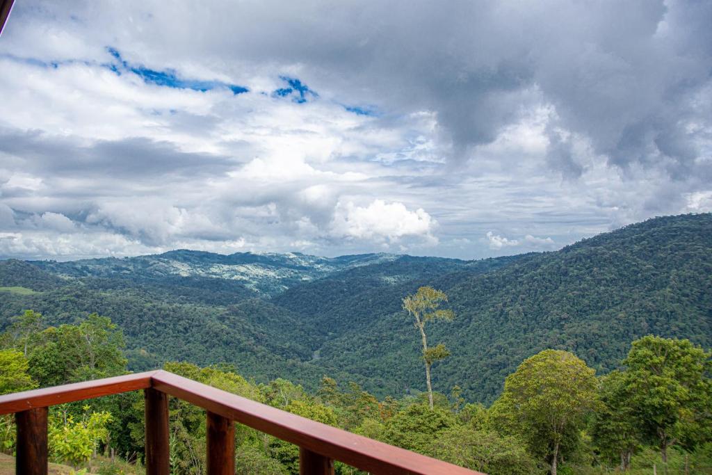 a view of a mountain valley from a wooden railing at Pacuare Mountain Lodge in Tres Equis