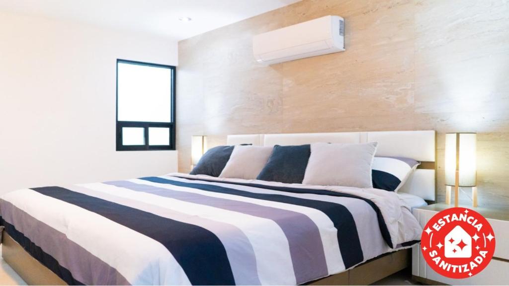 ECONOSUITES FUNDIDORA في مونتيري: غرفة نوم بسرير وبطانية مخططة سوداء وبيضاء