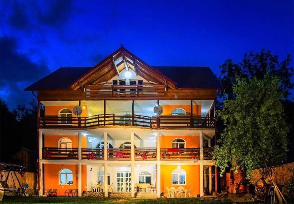 a large house with a balcony at night at Casa Cristalina&Dumi in Albac