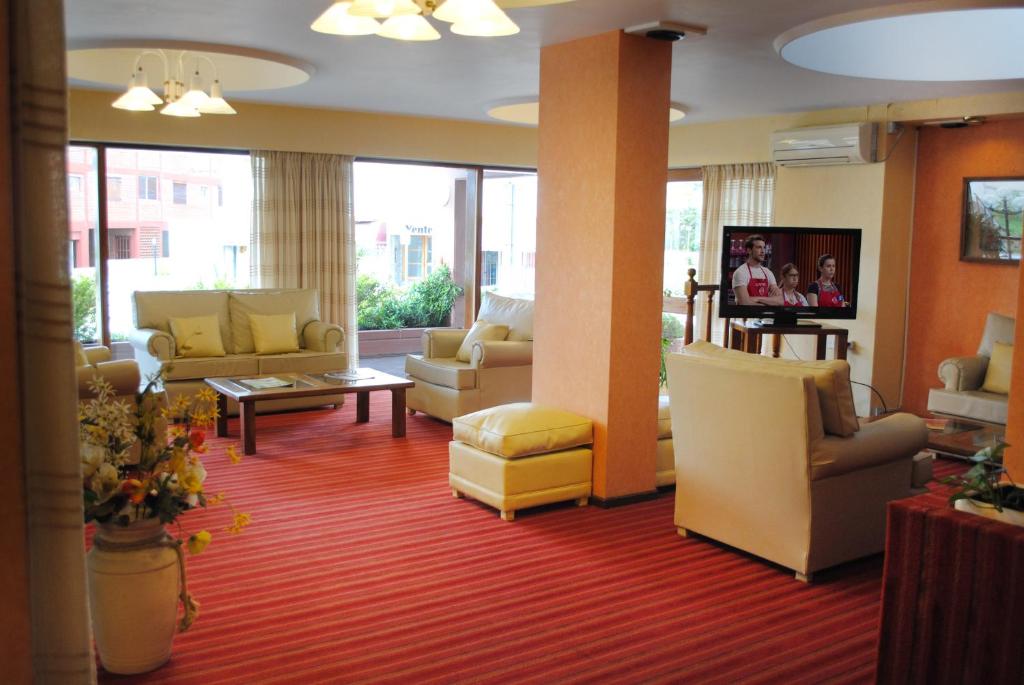 una sala de espera con sofás y sillas en un vestíbulo del Hotel Gran International de Villa Gesell