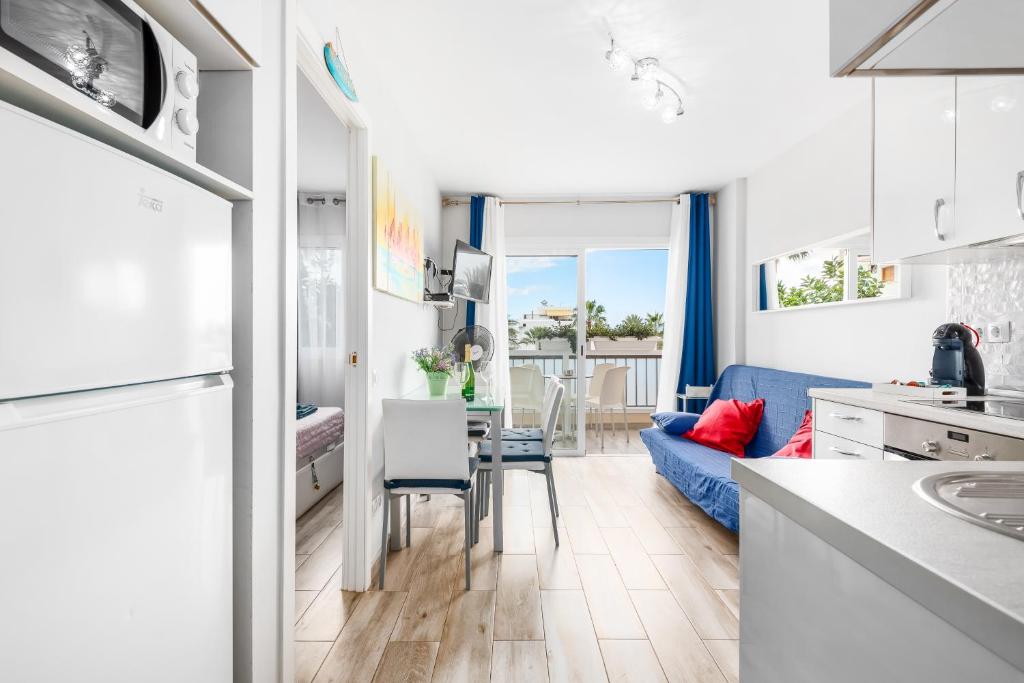 una cucina e un soggiorno con divano blu di Apartamento El Dorado, Wi-Fi y aparcamiento gratuito a Playa de las Americas