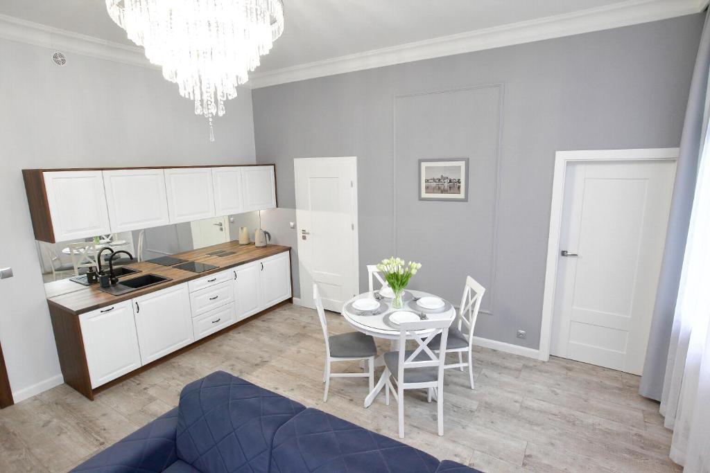 eine Küche und ein Esszimmer mit einem Tisch und Stühlen in der Unterkunft Apartament Kryształowy in Toruń