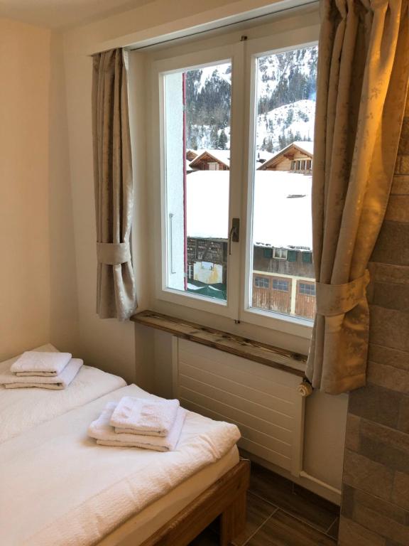 a bedroom with two twin beds and a window at STUDIO THE COW in Kandersteg