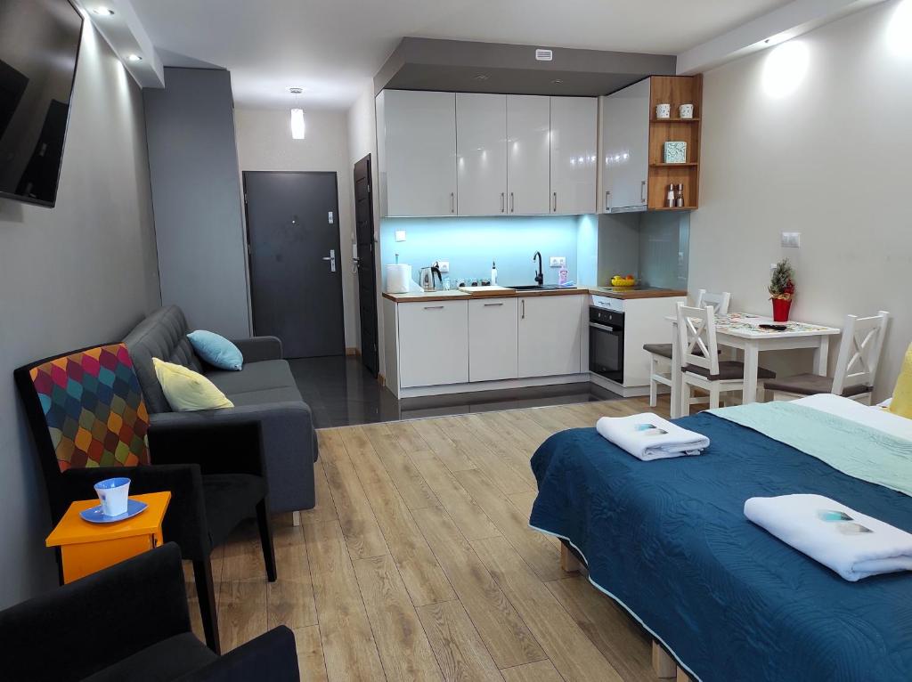 een kamer met een bed, een keuken en een woonkamer bij Apartamentylove - Apartament Kiliński in Łódź