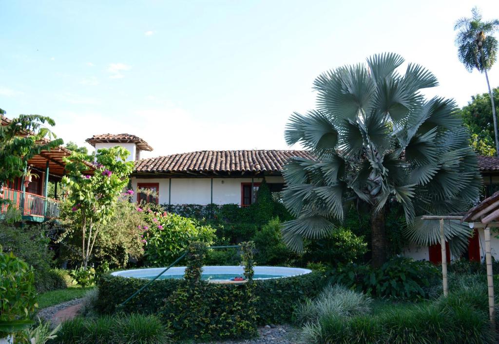 ein Haus mit einer Palme im Hof in der Unterkunft Finca La Argelia in Quimbaya
