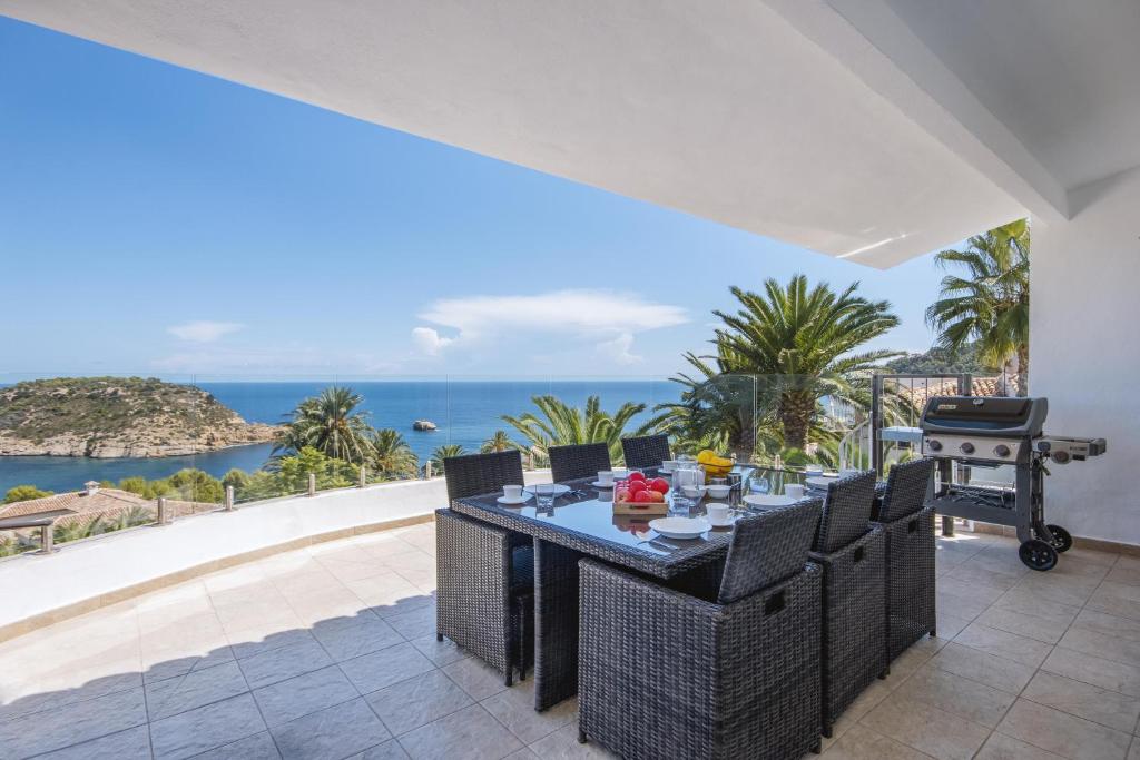 a patio with a table and a view of the ocean at Villa Suria in Jávea