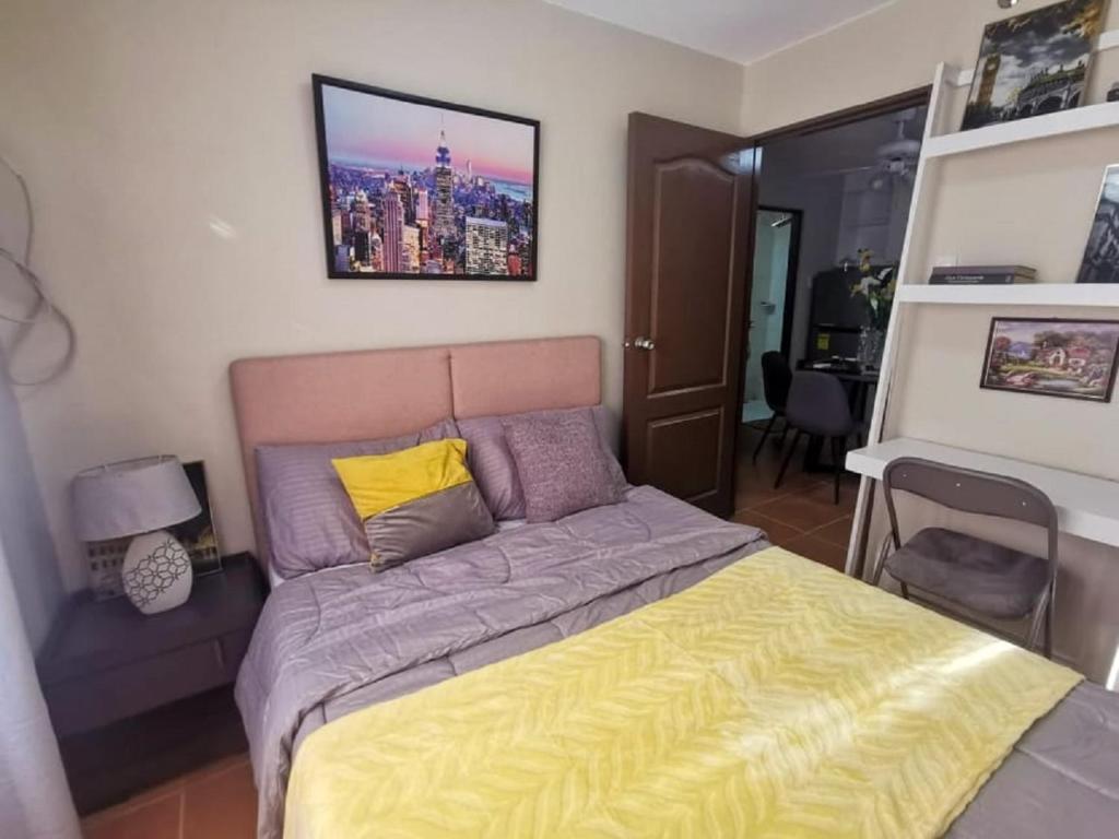 ein Schlafzimmer mit einem Bett mit einer gelben Decke in der Unterkunft One Oasis Apartment CDO in Cagayan de Oro