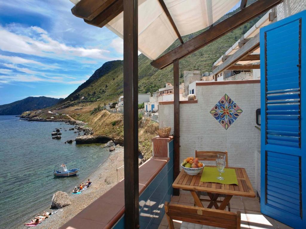 balcón con mesa y vistas al agua en Casa Marettimo, en Marettimo