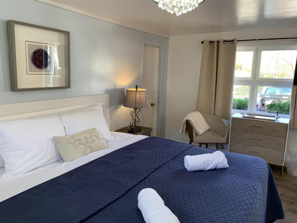 a bedroom with a large bed with a blue blanket at Starlight Lodge at Rockport Harbor in Rockport