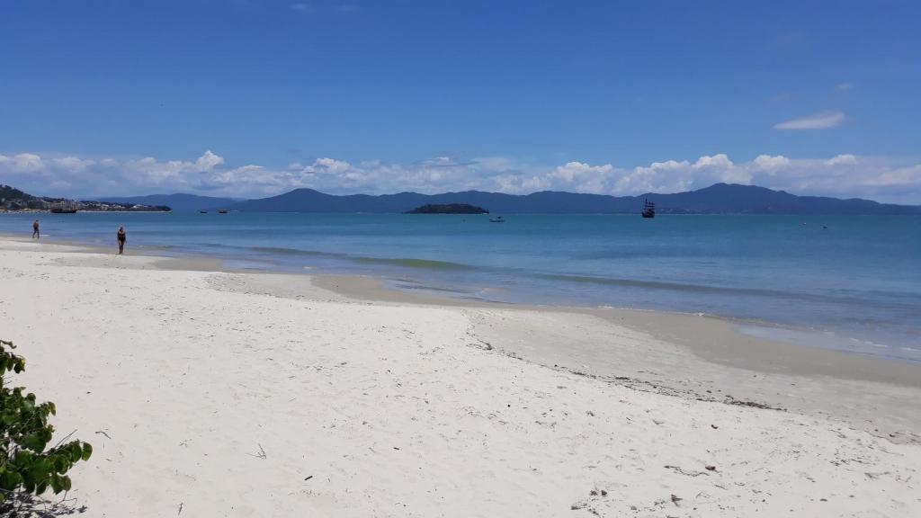 una playa de arena blanca con gente en el agua en Sol da Cachoeira, en Florianópolis