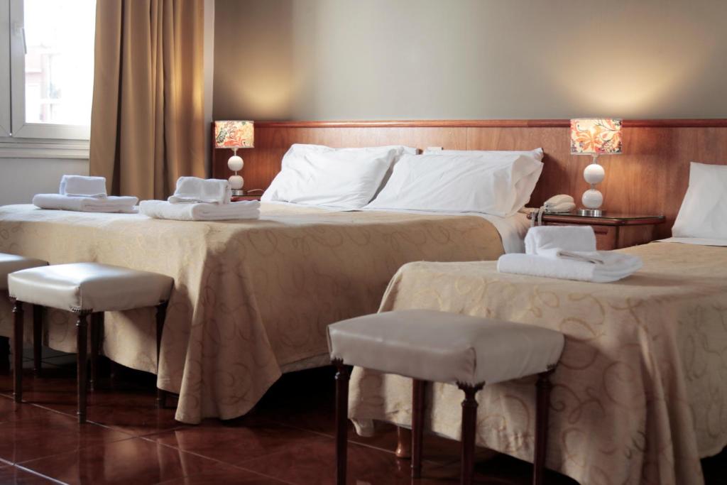 Habitación de hotel con 2 camas y 2 taburetes en Hotel Ortegal en Mar del Plata