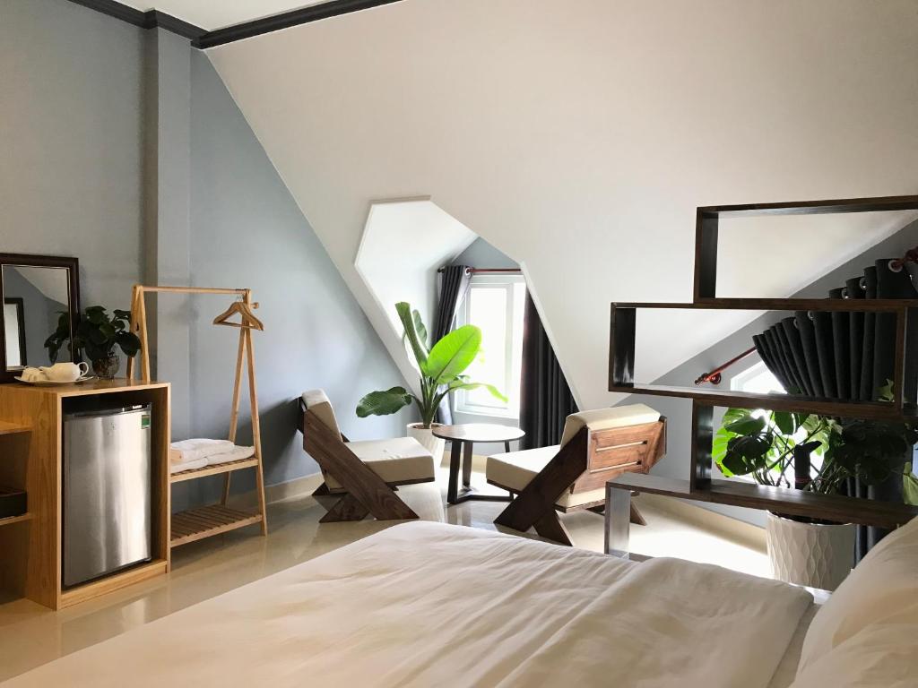 sypialnia z łóżkiem, stołem i krzesłami w obiekcie CozyNook Boutique Apartments - 3 thang 2 Street w mieście Da Lat