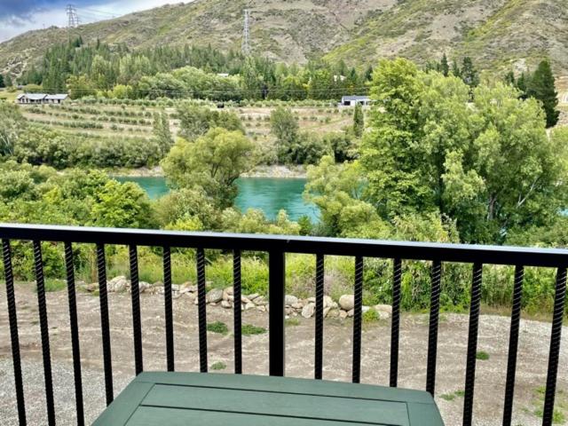 a green bench sitting on a balcony overlooking a river at Miners Lane B&B in Clyde