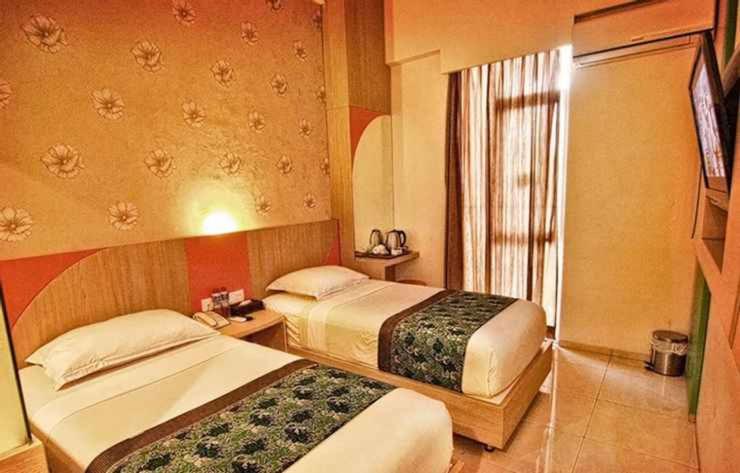 Cette chambre comprend 2 lits et une fenêtre. dans l'établissement Hotel Dewarna Sutoyo Malang, à Malang