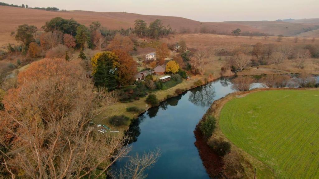 an aerial view of a river in a field at Umzimkulu River Lodge in Underberg