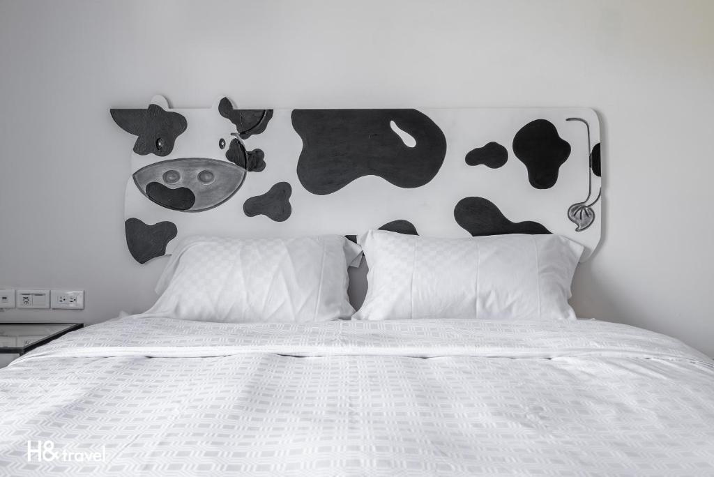 a bedroom with a bed with cows on the wall at Fairyland &amp; Farm Guest House in Kenting