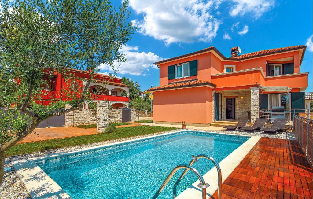 a home with a swimming pool in front of a house at Cozy Home In Umag With Wifi in Murine