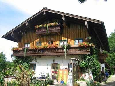 a building with a balcony with flowers on it at Haus Obinger in Reit im Winkl