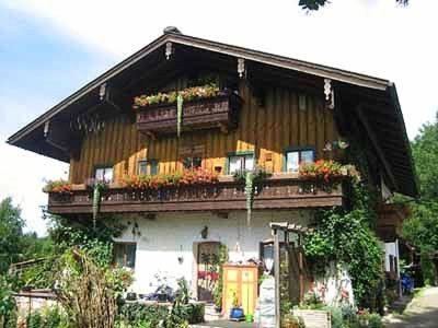 a building with a balcony with flowers on it at Beim Christal in Reit im Winkl