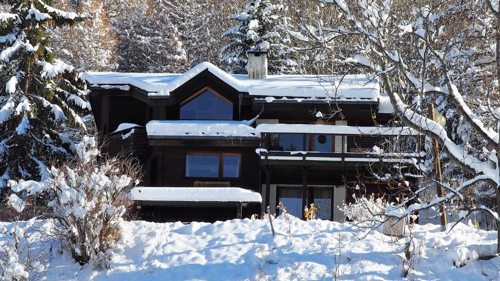 une maison recouverte de neige dans les bois dans l'établissement La Sauvagine B&B Skis aux pieds, aux Orres