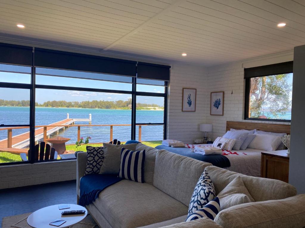 a living room with a couch and a bed at Serenity by the Lake - Romantic Waterfront Couple's Getaway in Marks Point