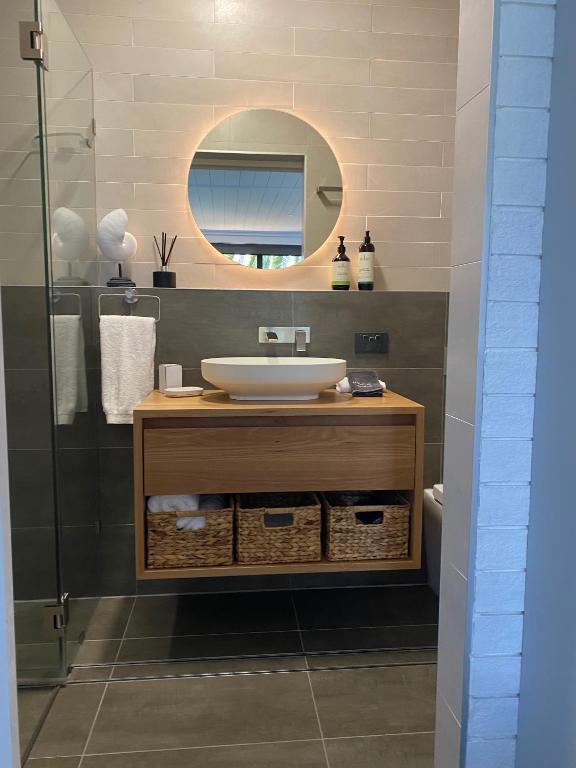 a bathroom with a sink and a mirror at Serenity by the Lake - Romantic Waterfront Couple's Getaway in Marks Point