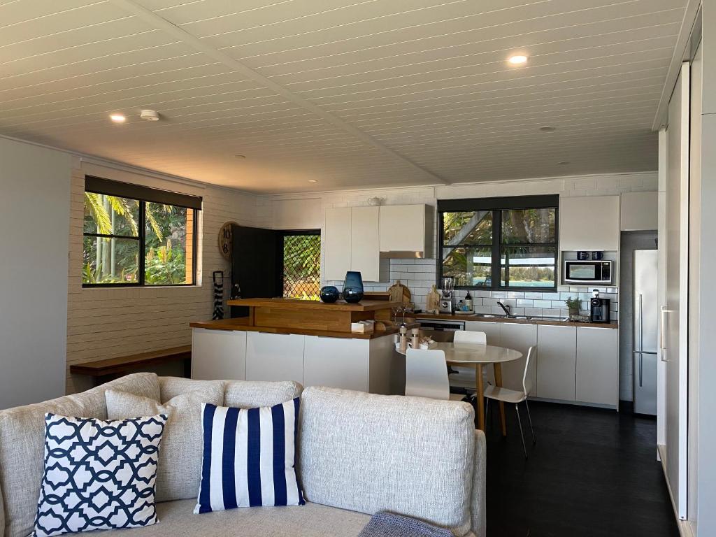 a living room with a couch and a kitchen at Serenity by the Lake - Romantic Waterfront Couple's Getaway in Marks Point