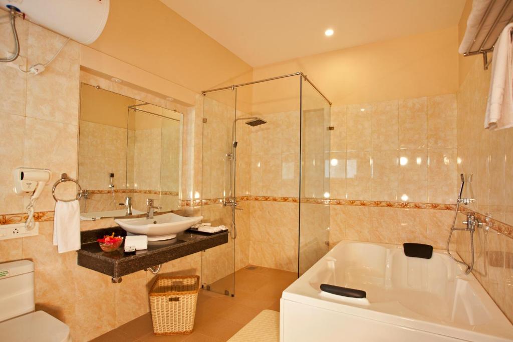 a bathroom with a tub and a sink and a shower at Resort De Coracao - Corbett , Uttarakhand in Rāmnagar