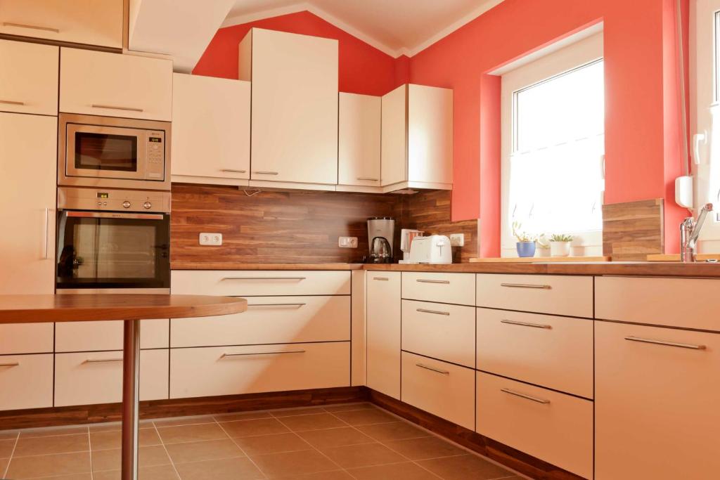 una cocina con armarios blancos y una mesa. en Familien Ferien Wohnung by Holzbau, en Scheßlitz