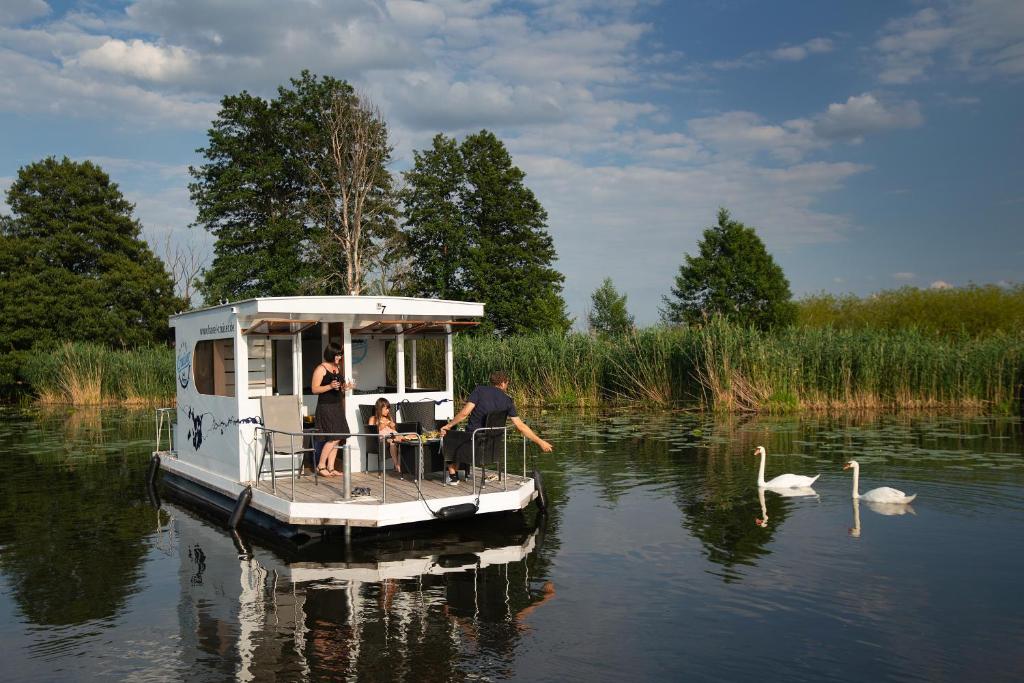 eine Gruppe von Menschen auf einem kleinen Boot auf dem Wasser in der Unterkunft Havel Cruiser - Hausboot-Flöße mit Stil in Brandenburg an der Havel