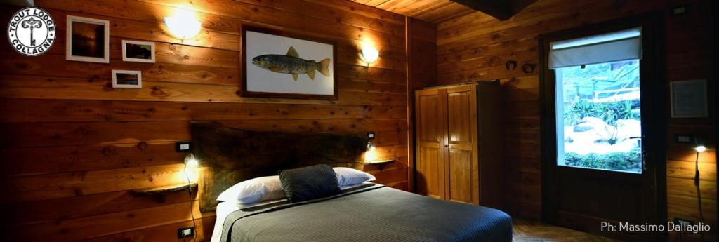 a bedroom with a bed in a wooden wall at Trout Lodge in Collagna