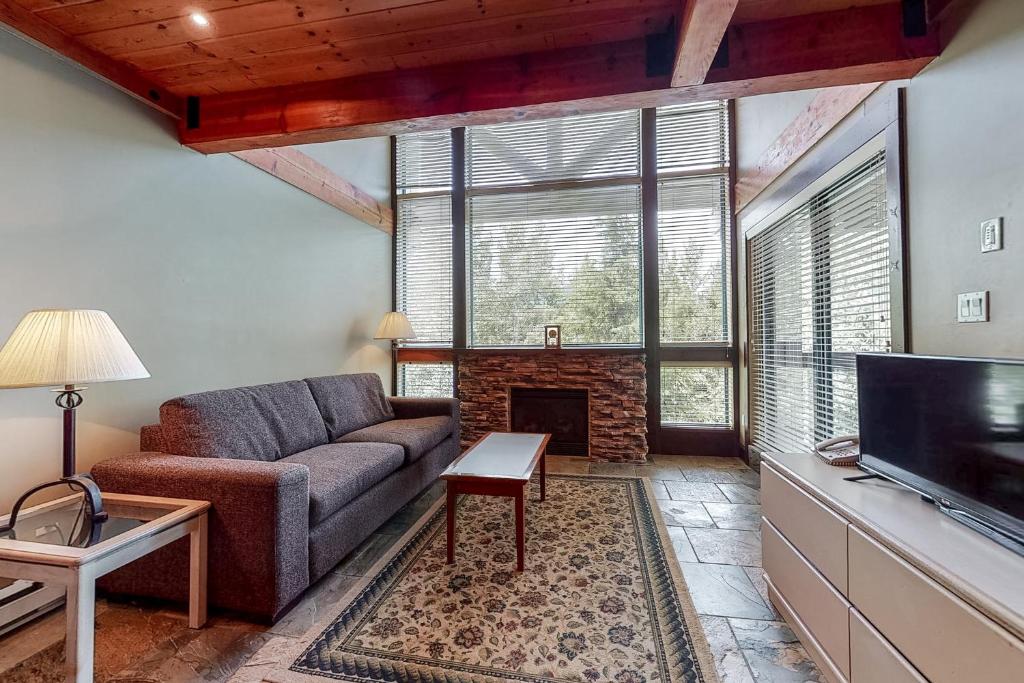 sala de estar con sofá y chimenea en Greystone Lodge 314&315, en Whistler