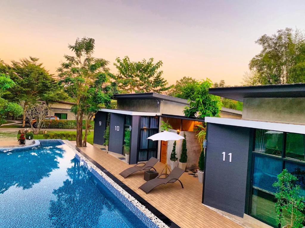 a villa with a swimming pool and a house at Baan Suan Leelawadee Resort Nan in Nan