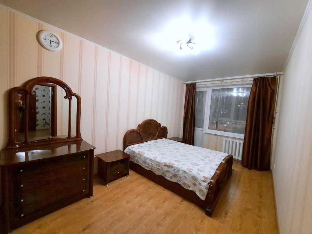 ウファにあるApartment Aiskaya 22のベッドルーム1室(ベッド1台、ドレッサー、窓付)