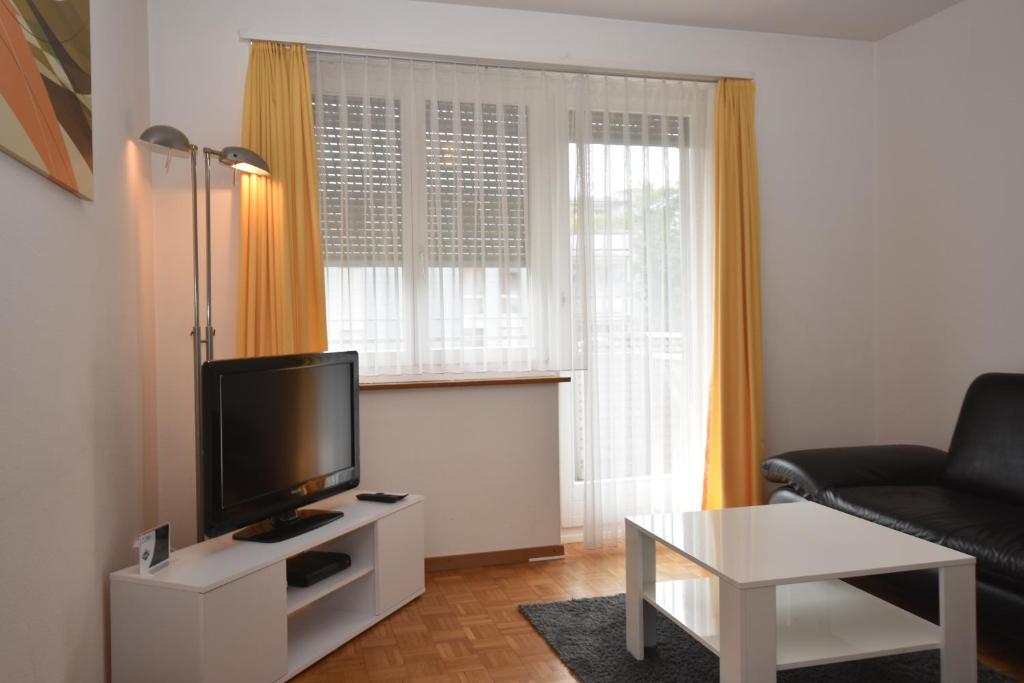 een woonkamer met een tv en een bank en een tafel bij PABS Résidences - Mühlebachstrasse 50 (1M) in Zürich