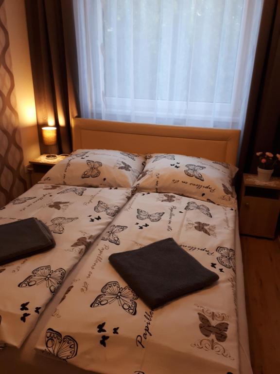 a bed with two pillows on it in a bedroom at Katalin Apartman in Hajdúszoboszló
