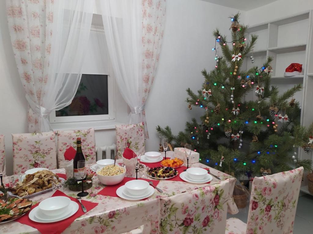 een kersttafel met een kerstboom in een kamer bij Гостьовий будиночок in Verbovatovka