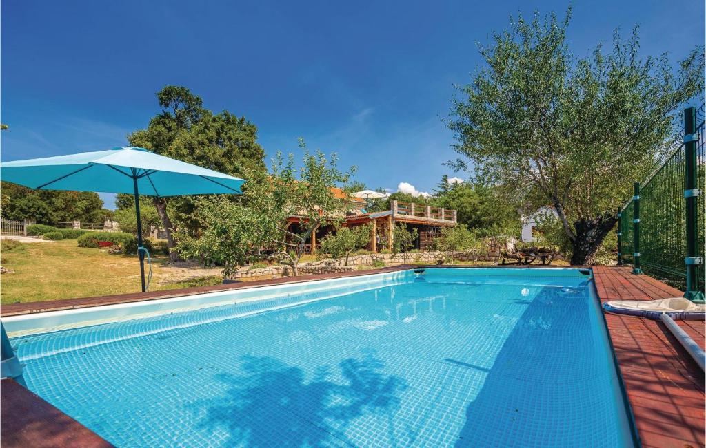 a swimming pool with an umbrella and a house at Pet Friendly Home In Ledenice With Kitchen in Ledenice